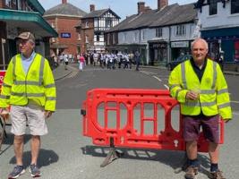 2  of the Rotary volunteers closing one of the streets while the Mayor's parade passed through.